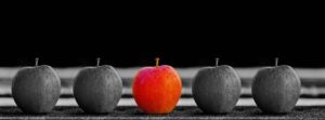 Row of five apples. the entire image is greyed out except for the center apple, which is red.